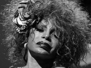 Elza Soares de olhos fechados ouvindo os músicos e plateia em palco